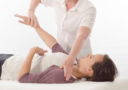 kinesiologue pratiquant le test musculaire sur le patient